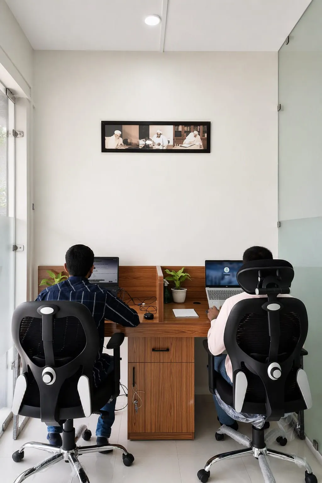Two team members working side by side at ZAH KPO workstations